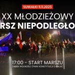 uczestnicy marszu niepodległości z biało-czerwonymi flagami w Suwałkach