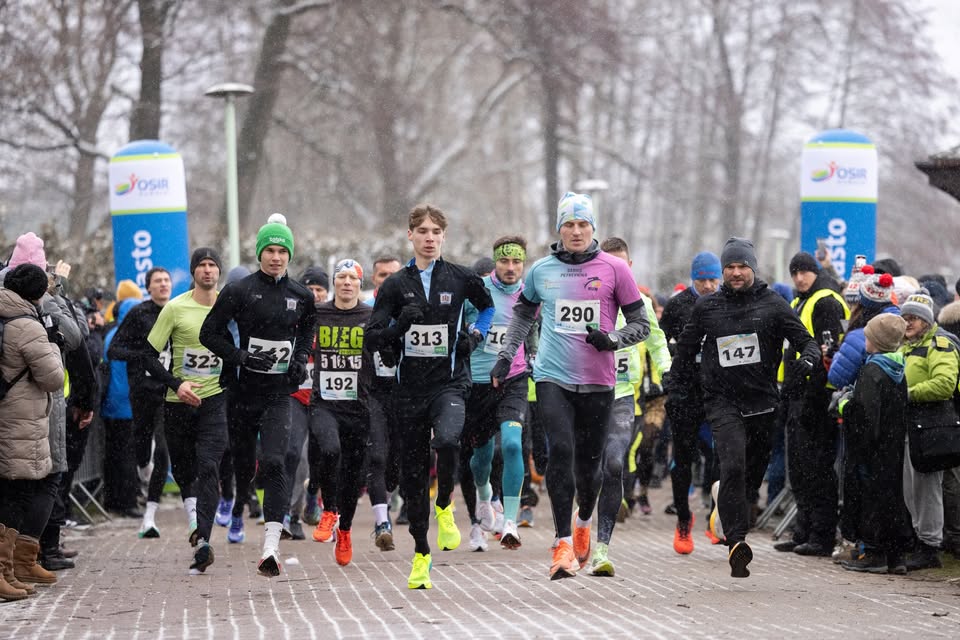 uczestnicy biegu karnawałowego w kolorowych przebraniach na tle zimowego krajobrazu