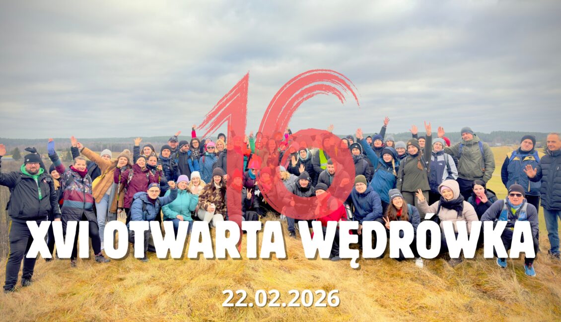 Uczestnicy wędrówki na szlaku w lesie.