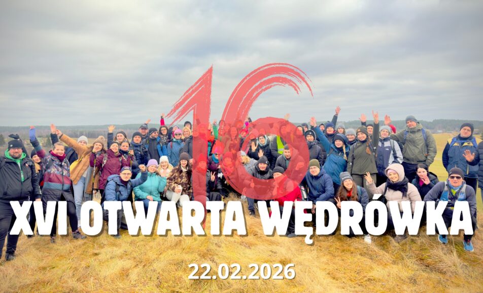 Uczestnicy wędrówki na szlaku w lesie.