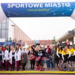 Uczestnicy biegów w kolorowych strojach na wydarzeniu sportowym w Suwałkach.