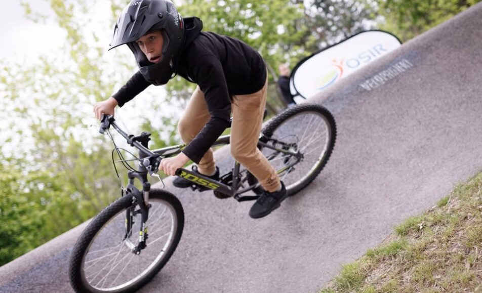 Ludzie na rowerach uczestniczący w wyścigu w parku rowerowym.