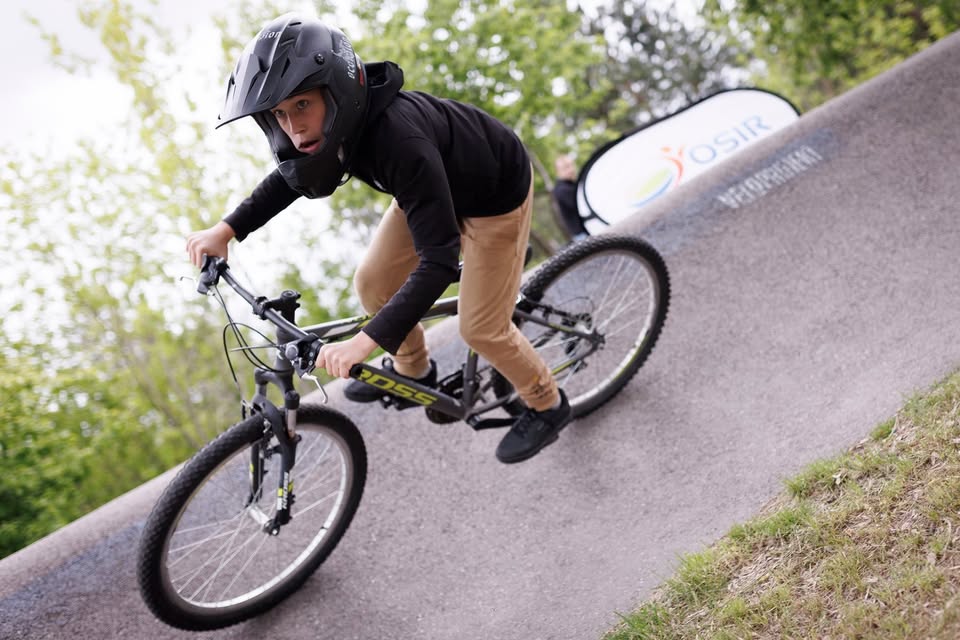 Ludzie na rowerach uczestniczący w wyścigu w parku rowerowym.